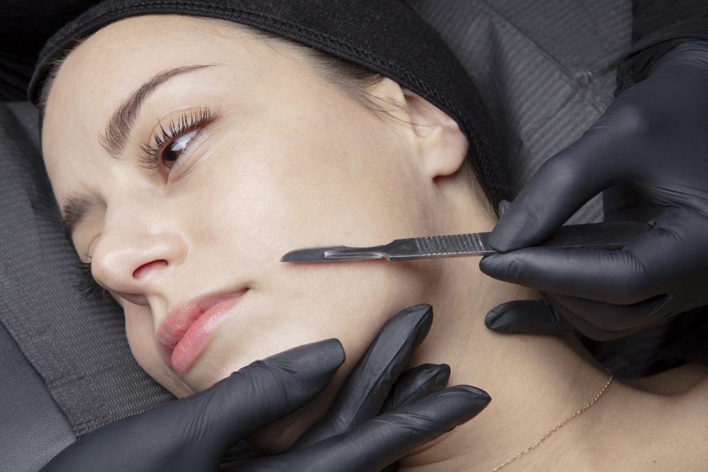 Esthetician performing dermaplaning facial